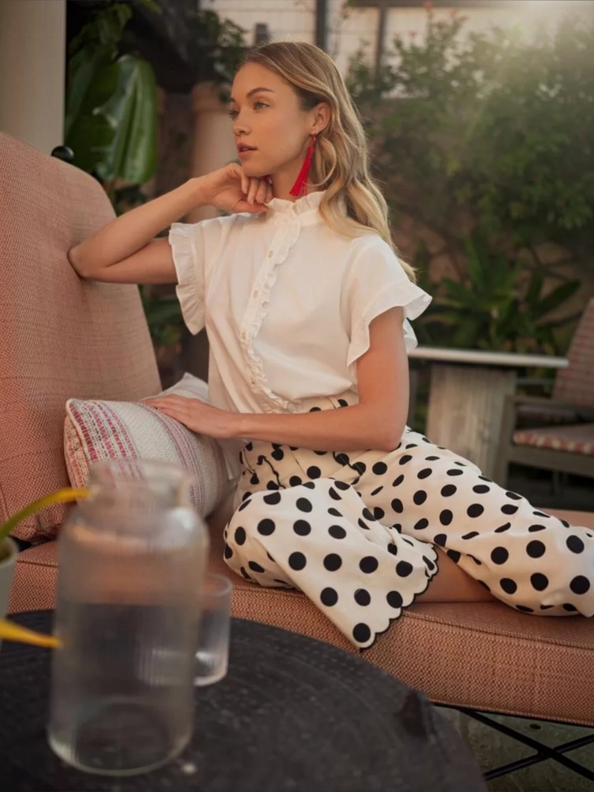 Woman wearing a Jodifl white ruffle collar button-down top styled with black polka dot pants